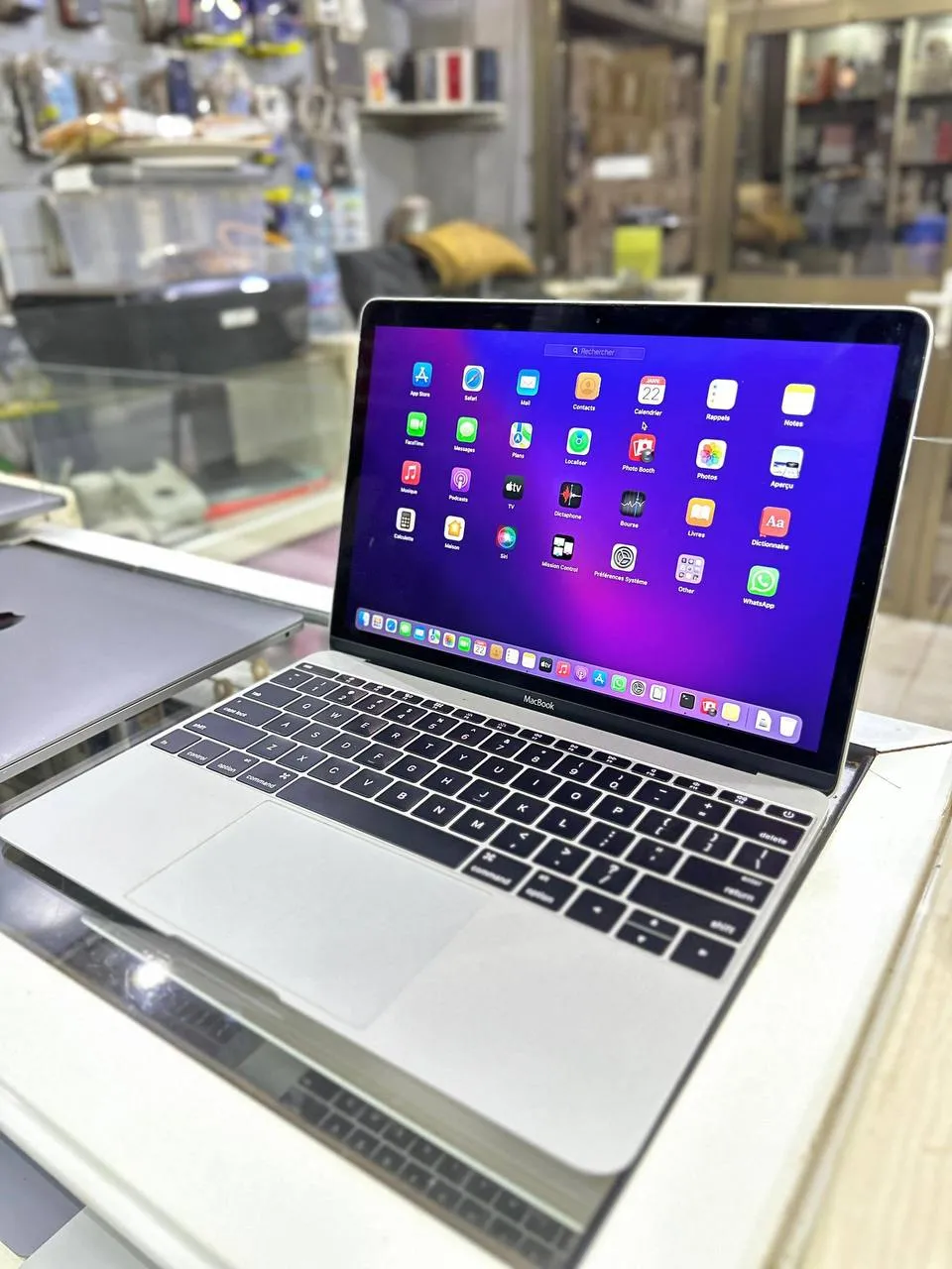Titre : MacBook en parfait état dans un environnement de boutique tech
